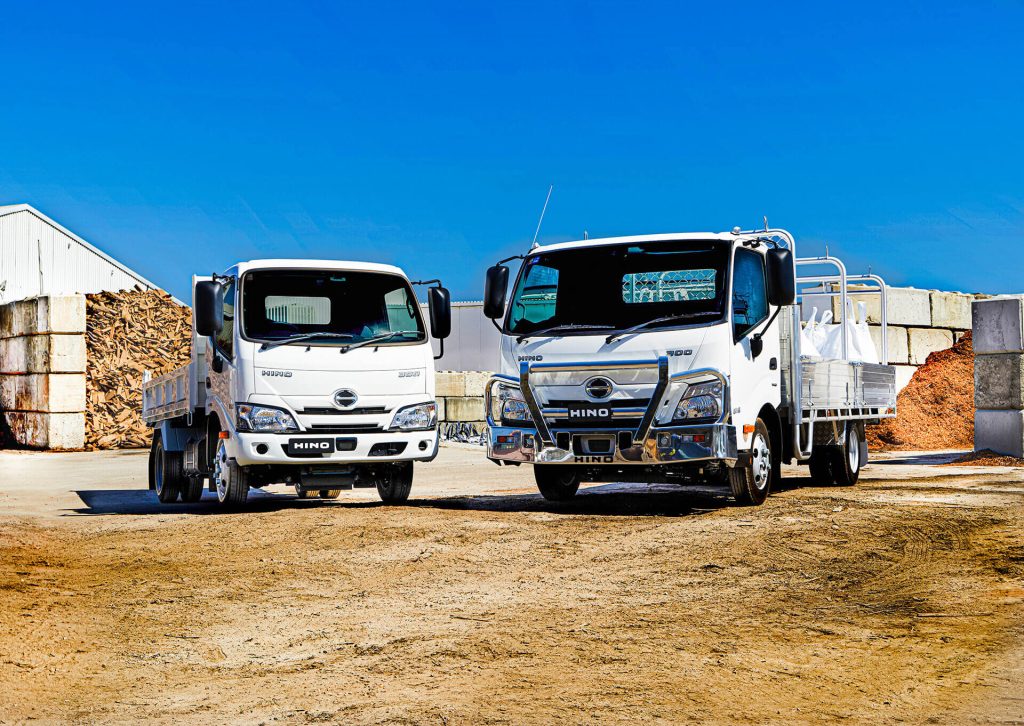 Two trucks parked on a dirt road
